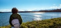 Woman watching lake Gabas in the Pyrenees Atlantiques, mountains in the background