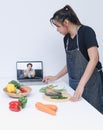 Woman watching and learn online cooking courses in the kitchen. Watching Cooking Video. Royalty Free Stock Photo