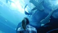 Woman is watching the life of the inhabitants of the aquarium