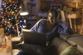 Woman watching movies on her laptop on Christmas Eve