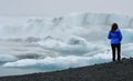 Woman watching on the shore Icebergs on Lake JÃÂ¶kulsÃÂ¡rlÃÂ³n in the VatnajÃÂ¶kull National Park on a foggy day