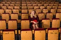 Woman watching stage performance in empty theater hall