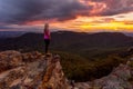 Woman watching storm clouds over Blue Mountains at sunset