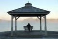 Woman watching sun rise as mist rises off lake Royalty Free Stock Photo