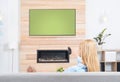 Woman watching TV on sofa in room with decorative fireplace