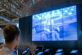 Woman watching video presentation about tolerance on large wall display