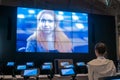 Woman watching video presentation about tolerance on large wall display