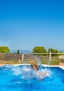 A woman in the water after jumping from the edge of a pool and with her head out of the water in the middle of strong waves with Royalty Free Stock Photo