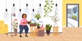 woman with watering can taking care of houseplants girl caring for indoor plants stay home lifestyle Royalty Free Stock Photo