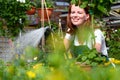 Woman watering flowers in a nursery - Greenhouse with coloured plants for sale Royalty Free Stock Photo