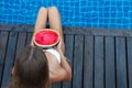Woman with watermelon poolside