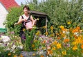 Woman waters flowers on summer residence