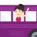 Woman waving hand from bus window.