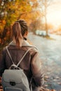 Woman wear aviator jacket looking throught the window with rain drops. Golden autumn leaves scene. Blurred tree-lined Royalty Free Stock Photo