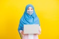 Woman wear hijab and face mask protective to prevent coronavirus she holding laptop Royalty Free Stock Photo