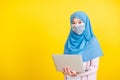 Woman wear hijab and face mask protective to prevent coronavirus she holding laptop Royalty Free Stock Photo