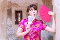 Woman wear pink cheongsam dress holding blow, red envelopes containing money for luck and prosperity family Royalty Free Stock Photo