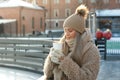 Woman wear white mittens holding steaming white cup of hot coffee or tea in cold winter sunny day Royalty Free Stock Photo