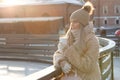 Woman wear white mittens holding steaming white cup of hot coffee or tea in cold winter sunny day Royalty Free Stock Photo