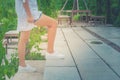 Woman wear white shirt and short jean, her is walking up concrete stairs outside the garden with green natural background. Royalty Free Stock Photo