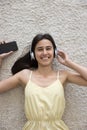 Woman wear wireless headphones holds smartphone listen music Royalty Free Stock Photo