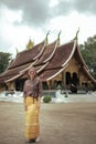 woman wearing asian tradition clothes standing infront of wat xiangthong temple one of most portant traveling destination in Royalty Free Stock Photo