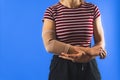 woman wearing a bandage on her elbow, studio shot blue background Royalty Free Stock Photo