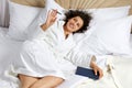 Woman Lying in big white Bed With Pen And Notepad Royalty Free Stock Photo