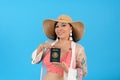 Woman wearing beach outfit showing her mexican passport.