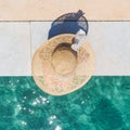 Woman wearing big summer sun hat relaxing on pier by clear turquoise sea. Royalty Free Stock Photo