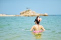 Woman wearing bikini standing at the sea.