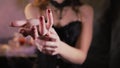 Woman is wearing a black corset dress. Hand reaches forward