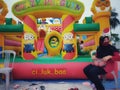 Woman wearing a black hijab sitting looking back in front of the children's playground by wearing a mask and faceshield