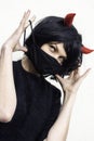 Woman wearing a black medical mask and a wig with red horns Royalty Free Stock Photo