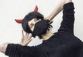 Woman wearing a black medical mask and a wig with red horns Royalty Free Stock Photo