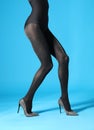 Woman wearing black tights and stylish shoes on blue, closeup of legs Royalty Free Stock Photo