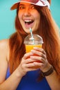 Woman wearing a blue swimsuit and hat drinks fruit juice from a cup Royalty Free Stock Photo