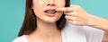 Woman wearing braces with sensitive teeth and hands touch the cheeks on blue background, Concept oral hygiene and health care