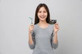 woman wearing braces with tooth and holding toothbrush and dentist tool, credit card on grey background. Royalty Free Stock Photo