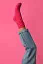 Woman wearing bright sock on pink background, closeup