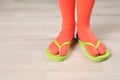 Woman wearing bright socks with flip-flops standing on floor Royalty Free Stock Photo