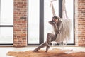 Woman wearing cashmere nightwear relaxing on hammock in cabin