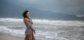 Woman wearing casual clothing enjoying sea storm and water waves of the sea on the beach Royalty Free Stock Photo