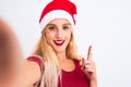 Woman wearing Christmas Santa hat make selfie by camera over isolated white background surprised with an idea or question pointing Royalty Free Stock Photo