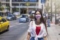 A woman wearing a cloth face mask walks on the busy streets of Athens