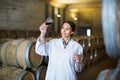 Woman wearing coat holding glass of wine on winery