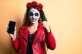 Woman wearing day of the dead costume holding smartphone showing screen annoyed and frustrated shouting with anger, yelling crazy Royalty Free Stock Photo