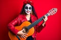 Woman wearing day of the dead costume playing classical guitar smiling and laughing hard out loud because funny crazy joke