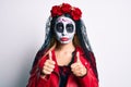Woman wearing day of the dead costume with thumbs up doing ok sign depressed and worry for distress, crying angry and afraid