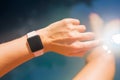 Woman wearing digital watch on hand by the pool